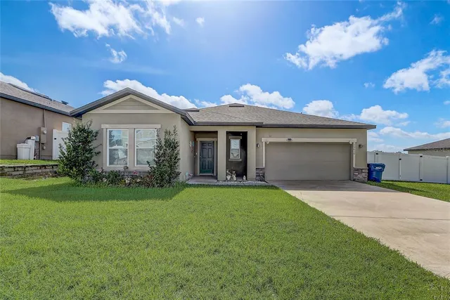 a front view of a house with a garden and yard