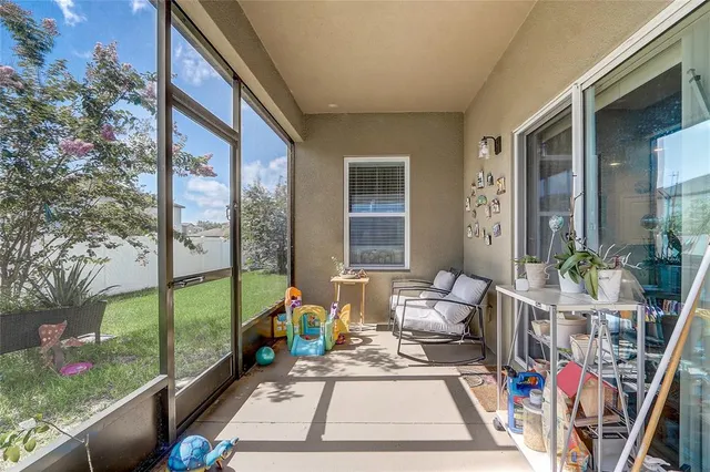 a living room with a large window and potted plants