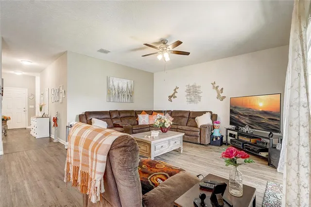 a living room with furniture kitchen view and a refrigerator