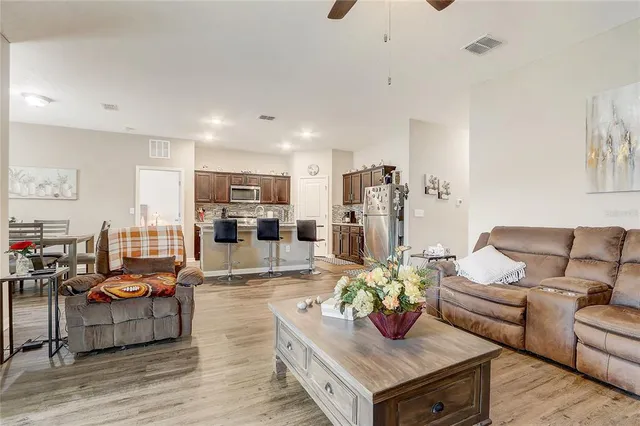 a kitchen with stainless steel appliances kitchen island granite countertop a refrigerator and a stove top oven