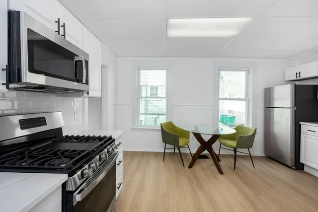 a kitchen with a table chairs and stainless steel appliances