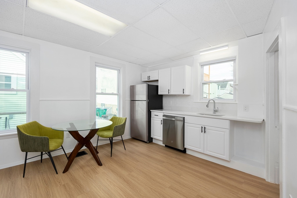 79 Brookline Street Lynn, MA 01902 - Photo 12 of 27 a kitchen with stainless steel appliances kitchen island hardwood floor sink and window