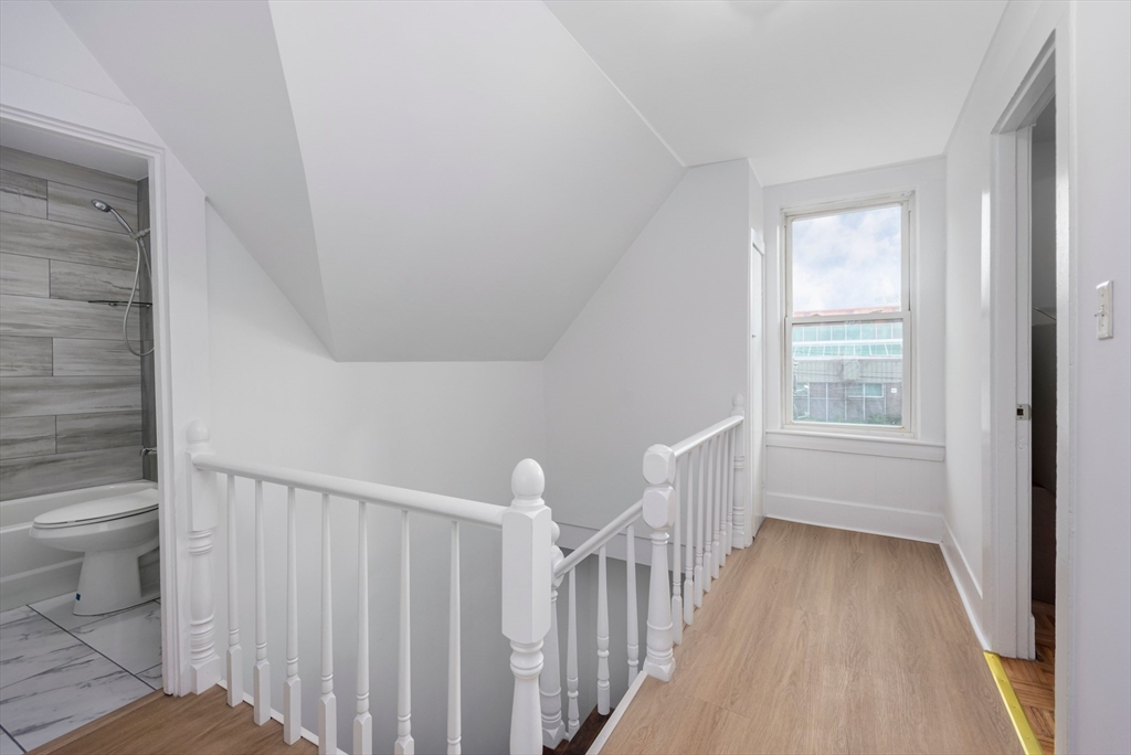 79 Brookline Street Lynn, MA 01902 - Photo 17 of 27 a view of a hallway with white walls and a window