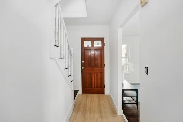 a view of a hallway with wooden floor and entryway