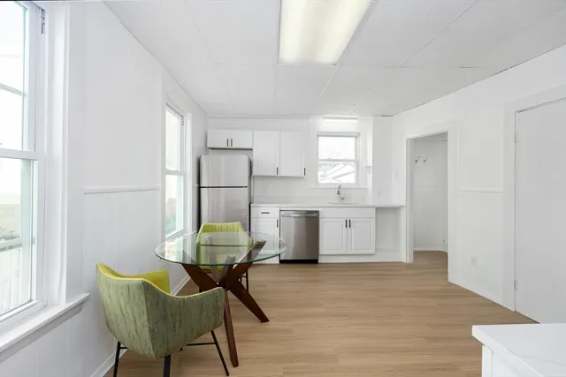 a kitchen with stainless steel appliances wooden floor and a refrigerator