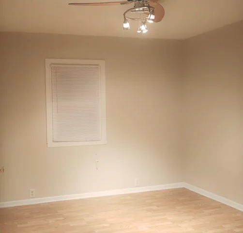 a view of a small space with wooden floor and a window