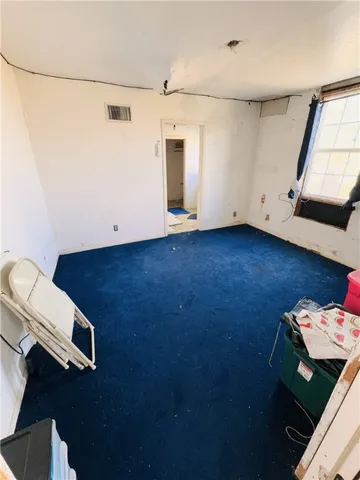 a view of a big room with wooden floor and windows