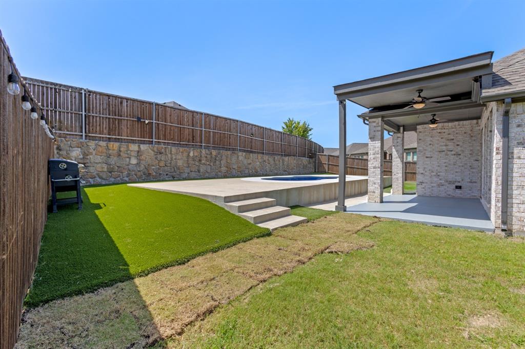 960 Knoxbridge Road Forney, TX 75126 - Photo 17 of 22 Backyard oasis featuring a kidney-shaped swimming pool with concrete decking, artificial turf, and a covered patio area