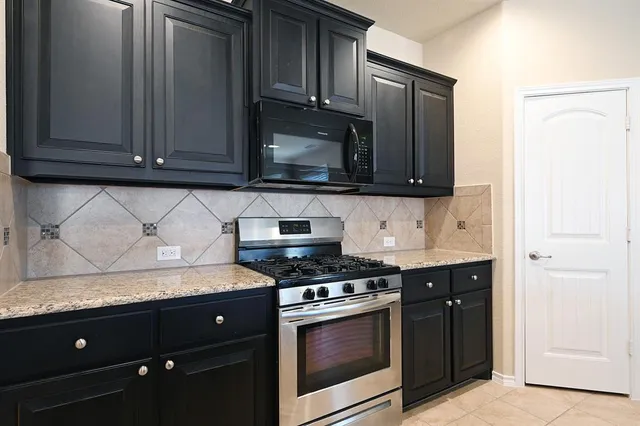 a kitchen with granite countertop stainless steel appliances and cabinets
