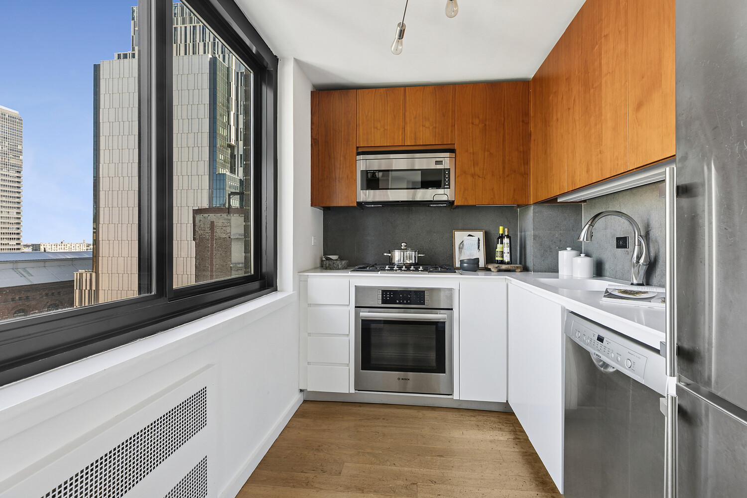 515 East 72nd Street, Unit 11L Manhattan, NY 10021 - Photo 12 of 19 a kitchen with stainless steel appliances granite countertop a stove a sink and a microwave