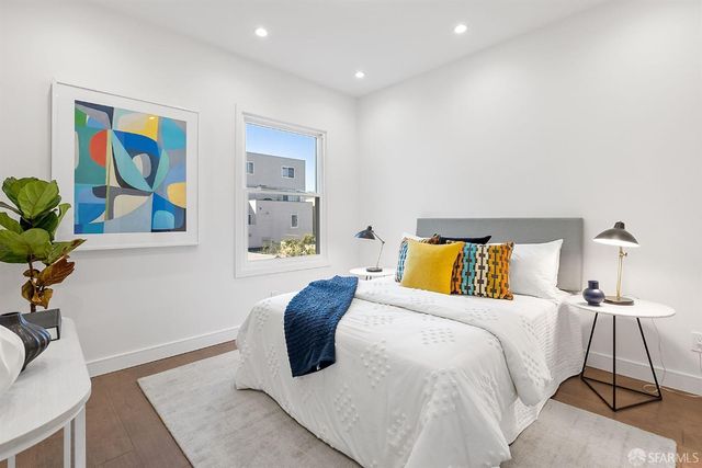 a bedroom with a bed and painting on the wall