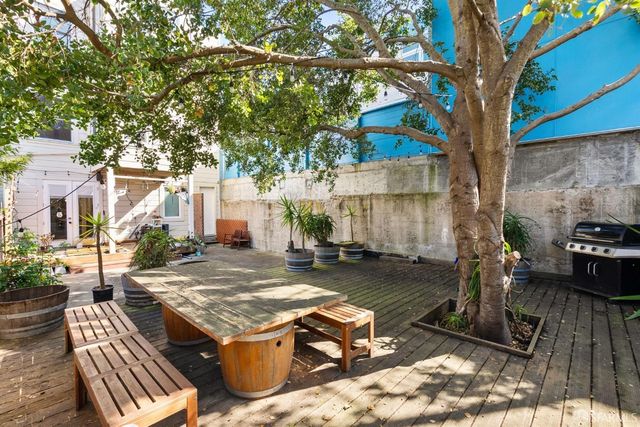 a view of a patio with table and chairs with wooden fence and plants