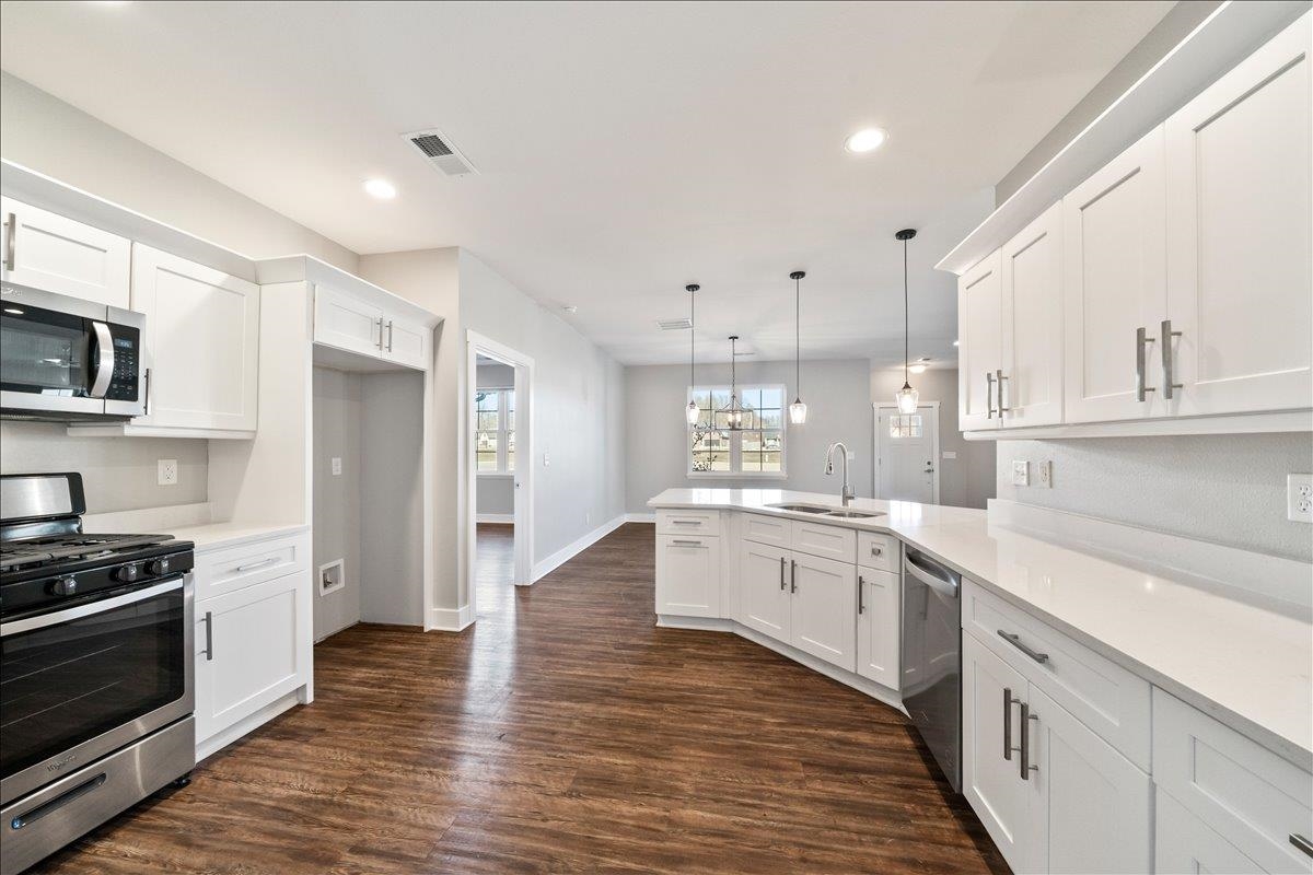 447 Abbey Road, Unit A Munford, TN 38058 - Photo 4 of 30 a large kitchen with stainless steel appliances cabinets a sink and a wooden floor