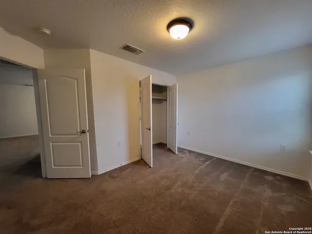 an empty room with windows and closet in it