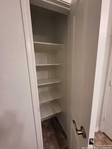 a view of a backyard with table and chairs under an umbrella with a small yard