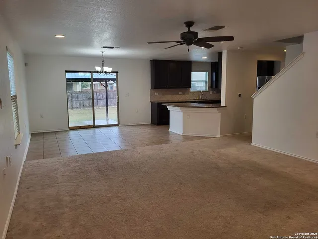 a view of room with a flat screen tv and kitchen view