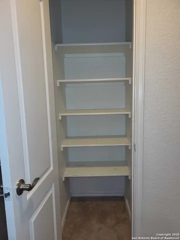 a view of walk in closet with empty racks