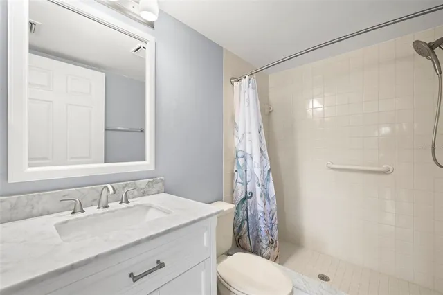 a bathroom with a granite countertop sink toilet and shower