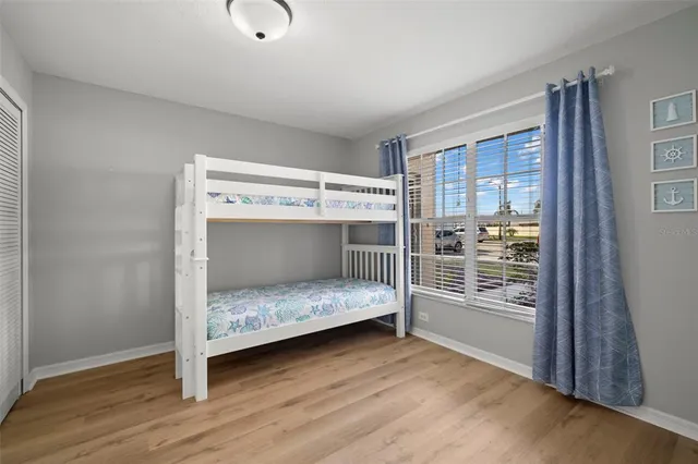 a bedroom with a bunk bed and a window