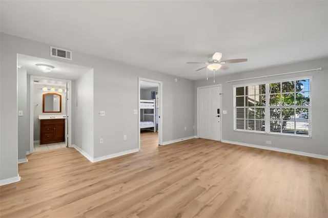 a view of an empty room with a window and wooden floor