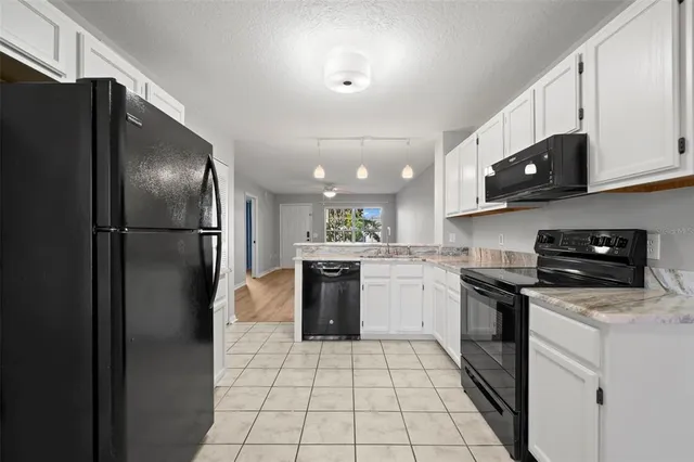 a kitchen with stainless steel appliances granite countertop a refrigerator a stove a sink and a microwave