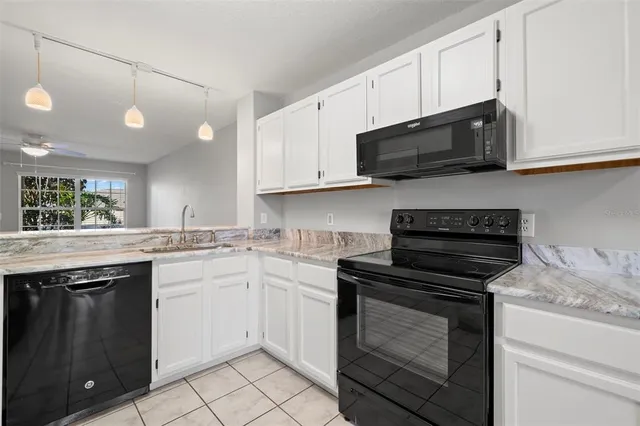 a kitchen with cabinets appliances a sink and a counter top space