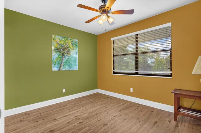 a view of a hallway to a bedroom with wooden floor and cabinet