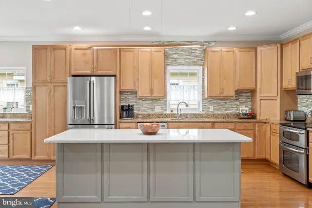 a kitchen with a sink a stove top oven a refrigerator and a kitchen island