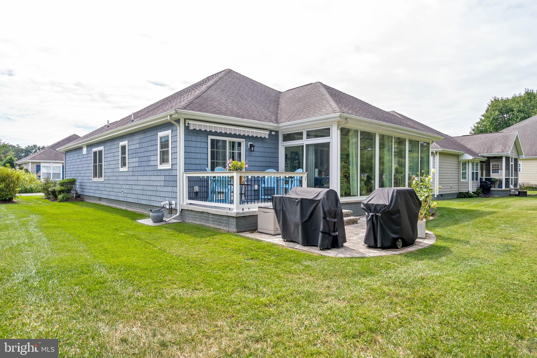 20234 Whitehead Circle, Unit 100 Rehoboth Beach, DE 19971 - Photo 2 of 40 a front view of a house with patio and garden