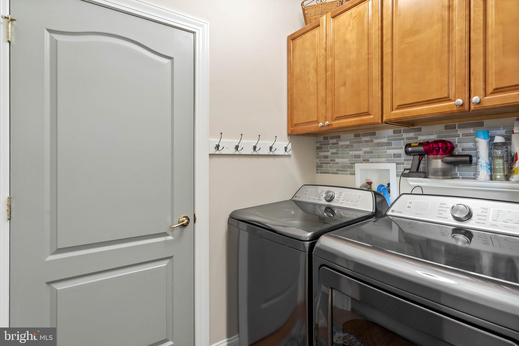 20234 Whitehead Circle, Unit 100 Rehoboth Beach, DE 19971 - Photo 25 of 40 a utility room with dryer and washer