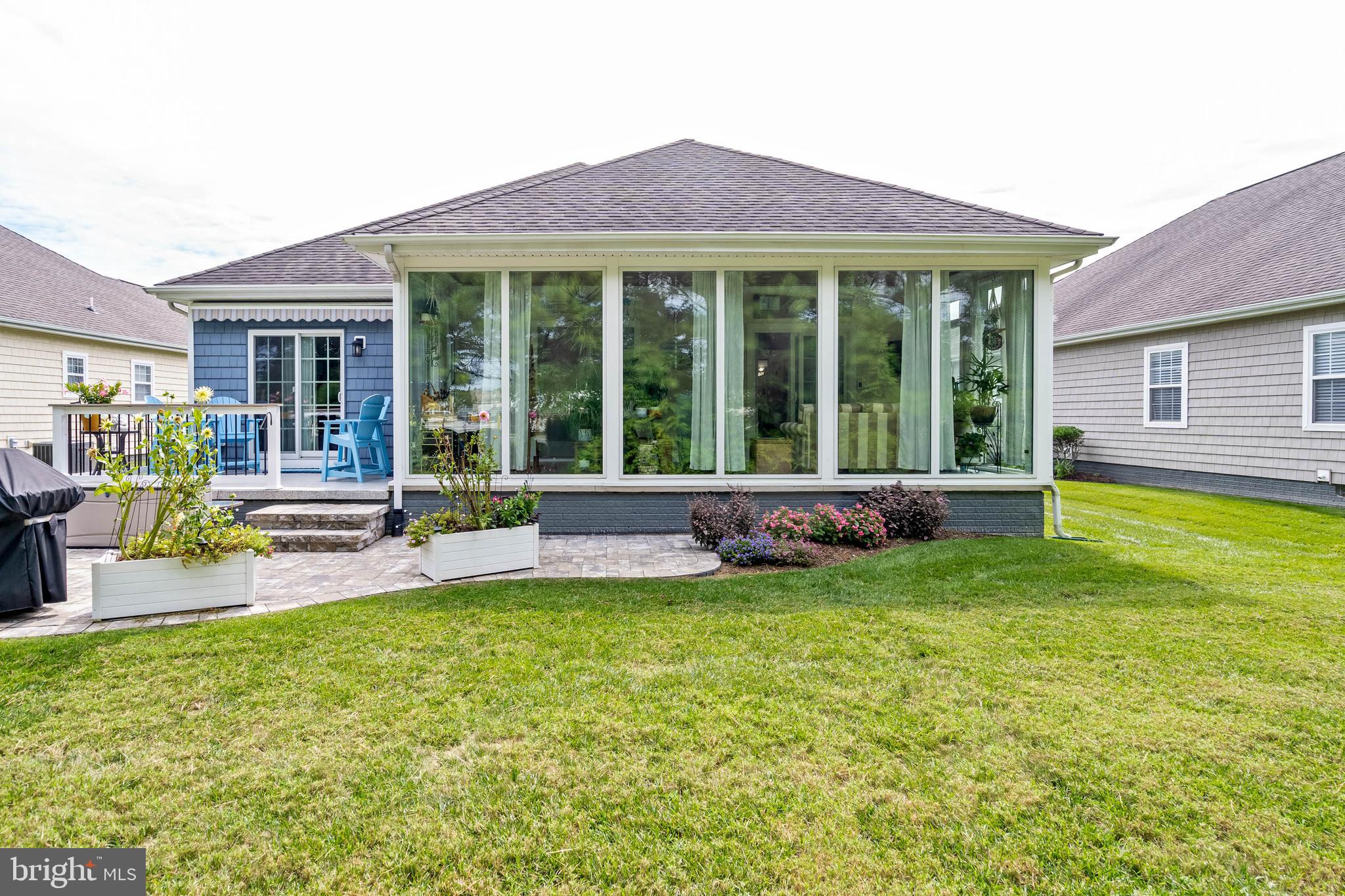 20234 Whitehead Circle, Unit 100 Rehoboth Beach, DE 19971 - Photo 29 of 40 a view of a house with a backyard and a patio