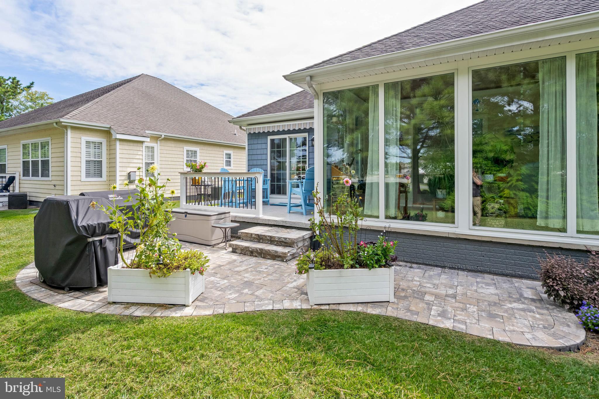 20234 Whitehead Circle, Unit 100 Rehoboth Beach, DE 19971 - Photo 30 of 40 a front view of a house with a garden and patio