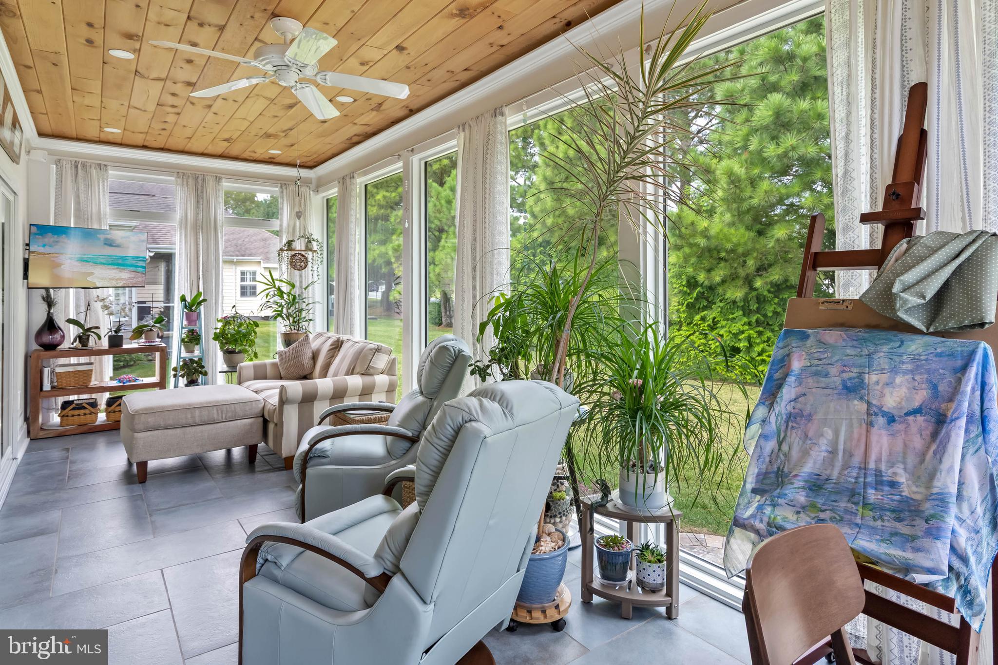 20234 Whitehead Circle, Unit 100 Rehoboth Beach, DE 19971 - Photo 6 of 40 a living room with patio furniture and a potted plant