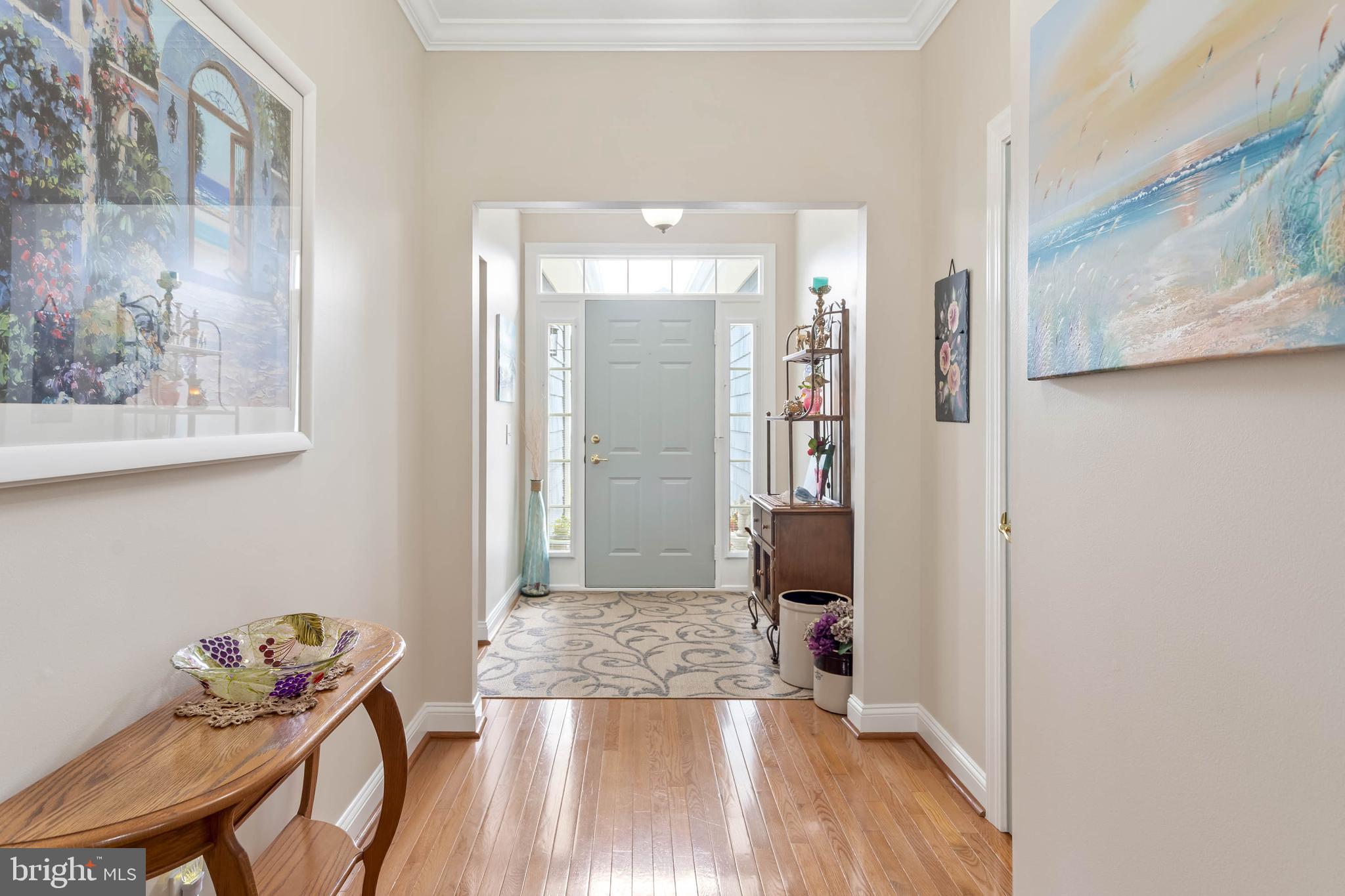 20234 Whitehead Circle, Unit 100 Rehoboth Beach, DE 19971 - Photo 7 of 40 a view of a hallway with wooden floor and a living room