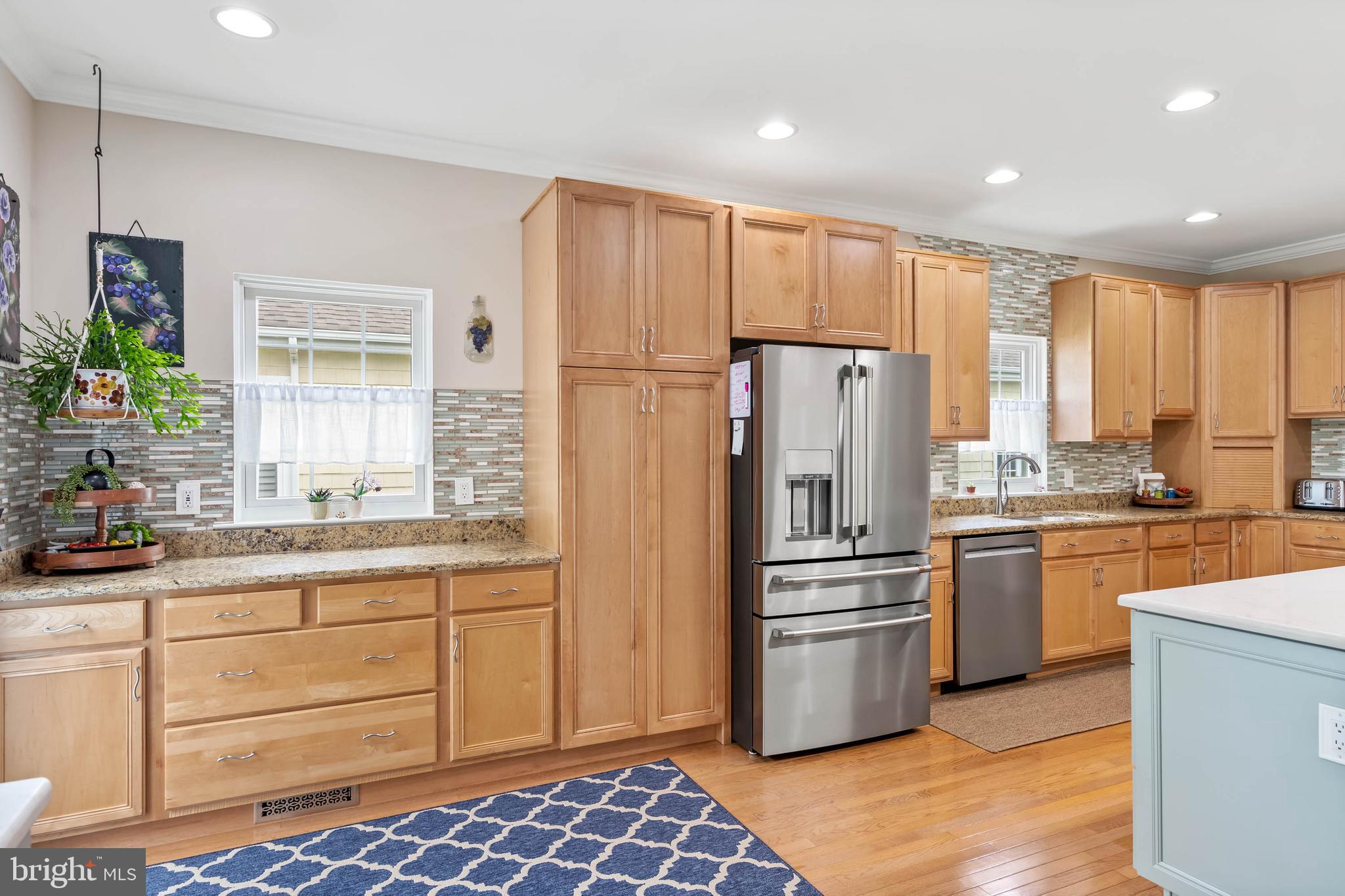 20234 Whitehead Circle, Unit 100 Rehoboth Beach, DE 19971 - Photo 10 of 40 a kitchen with stainless steel appliances a refrigerator sink and stove