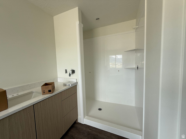 1008 West 3410 South Nibley, UT 84321 - Photo 15 of 26 Modern bathroom featuring a wood-finish vanity with a light speckled countertop and integrated sink
