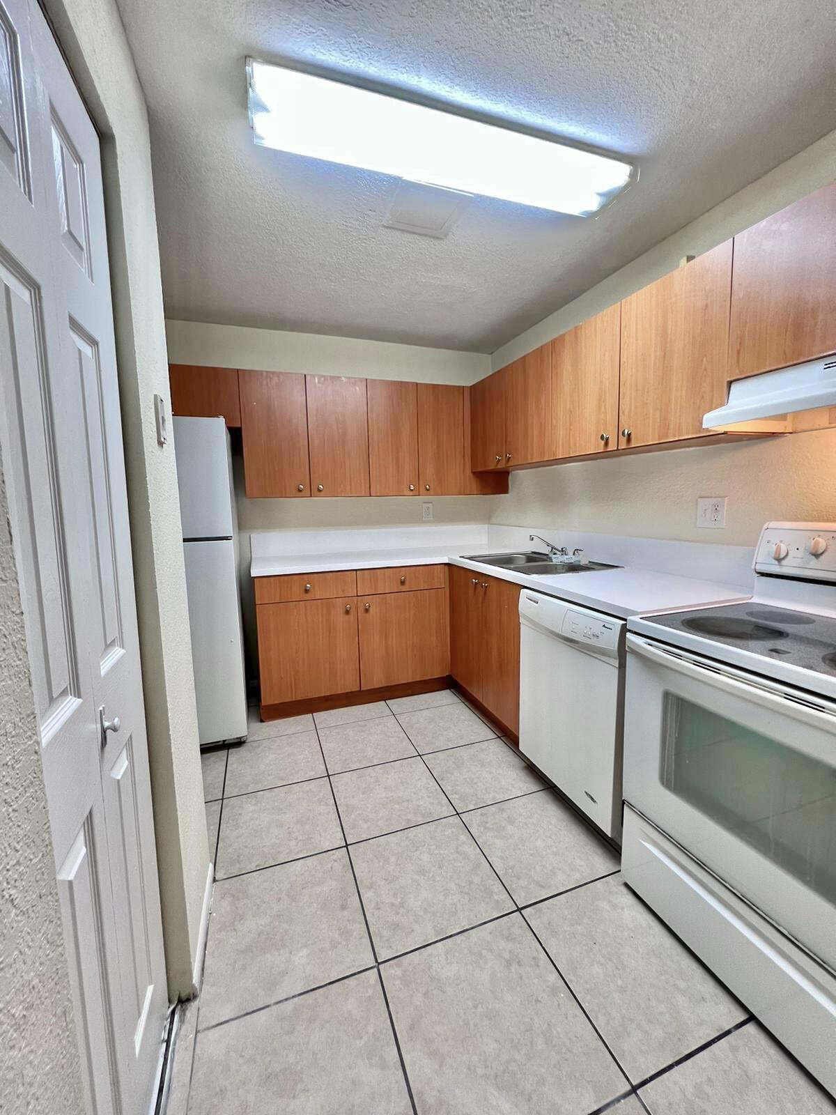 a kitchen with granite countertop a sink cabinets and stainless steel appliances