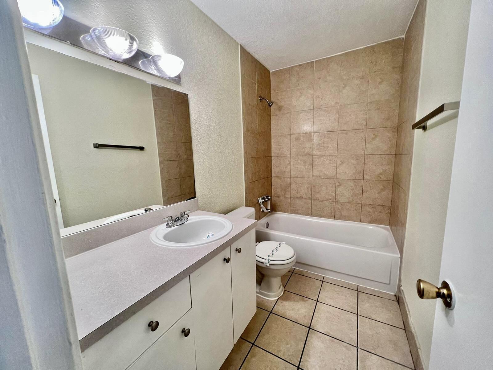 415 Executive Center Drive, Unit 213 West Palm Beach, FL 33401 - Photo 13 of 23 a bathroom with a sink a toilet and shower