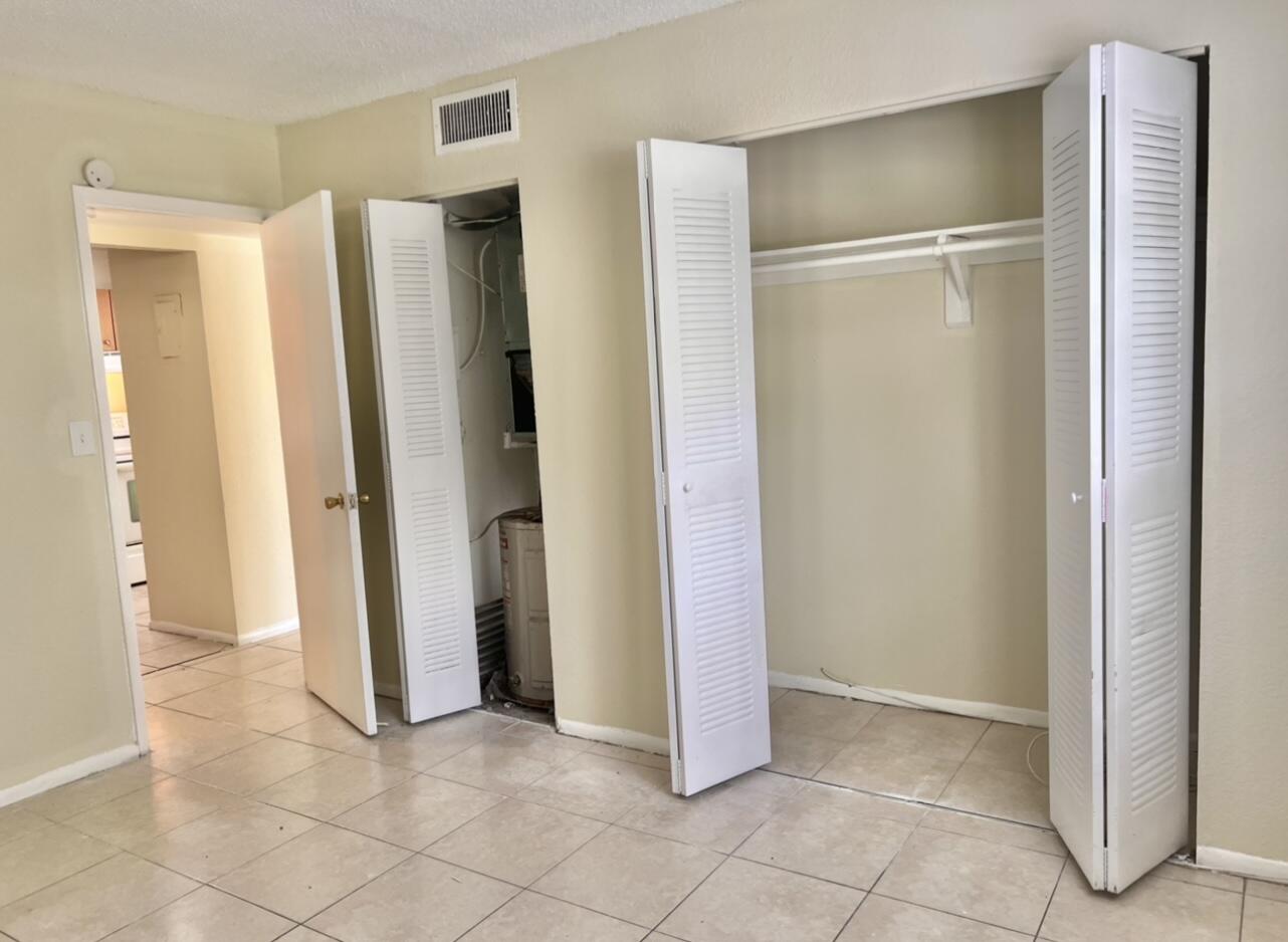415 Executive Center Drive, Unit 213 West Palm Beach, FL 33401 - Photo 15 of 23 a view of an empty room with closet and a fireplace