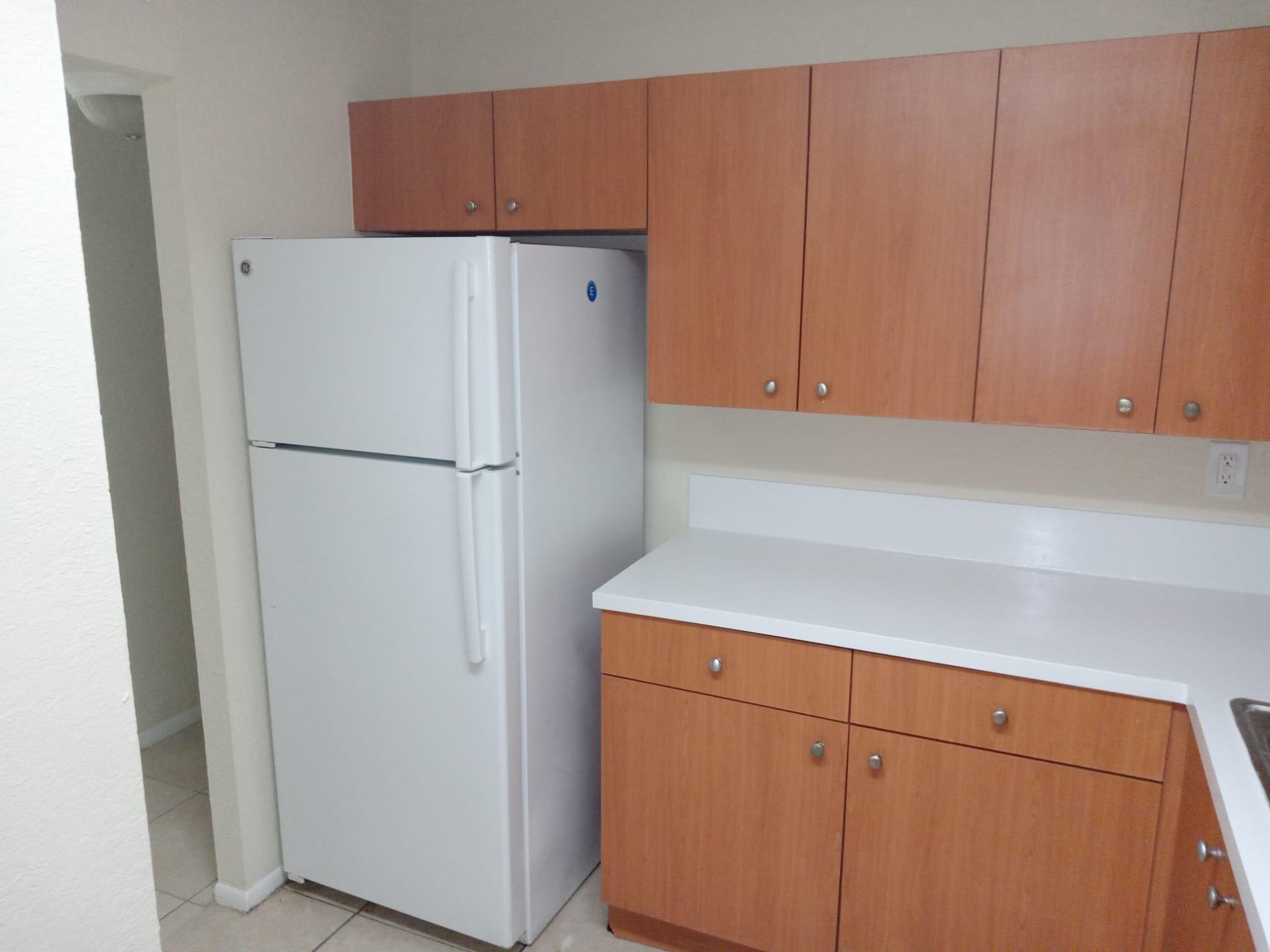415 Executive Center Drive, Unit 213 West Palm Beach, FL 33401 - Photo 4 of 23 a white refrigerator freezer sitting in a kitchen