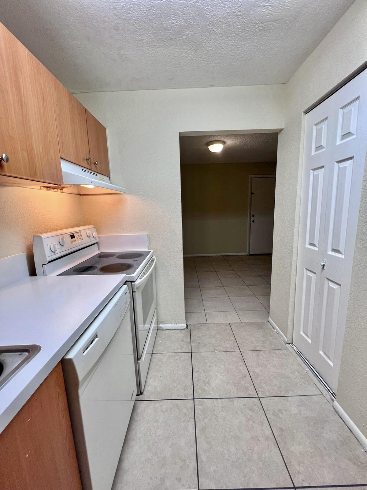 415 Executive Center Drive, Unit 213 West Palm Beach, FL 33401 - Photo 5 of 23 a view of kitchen with washer and dryer