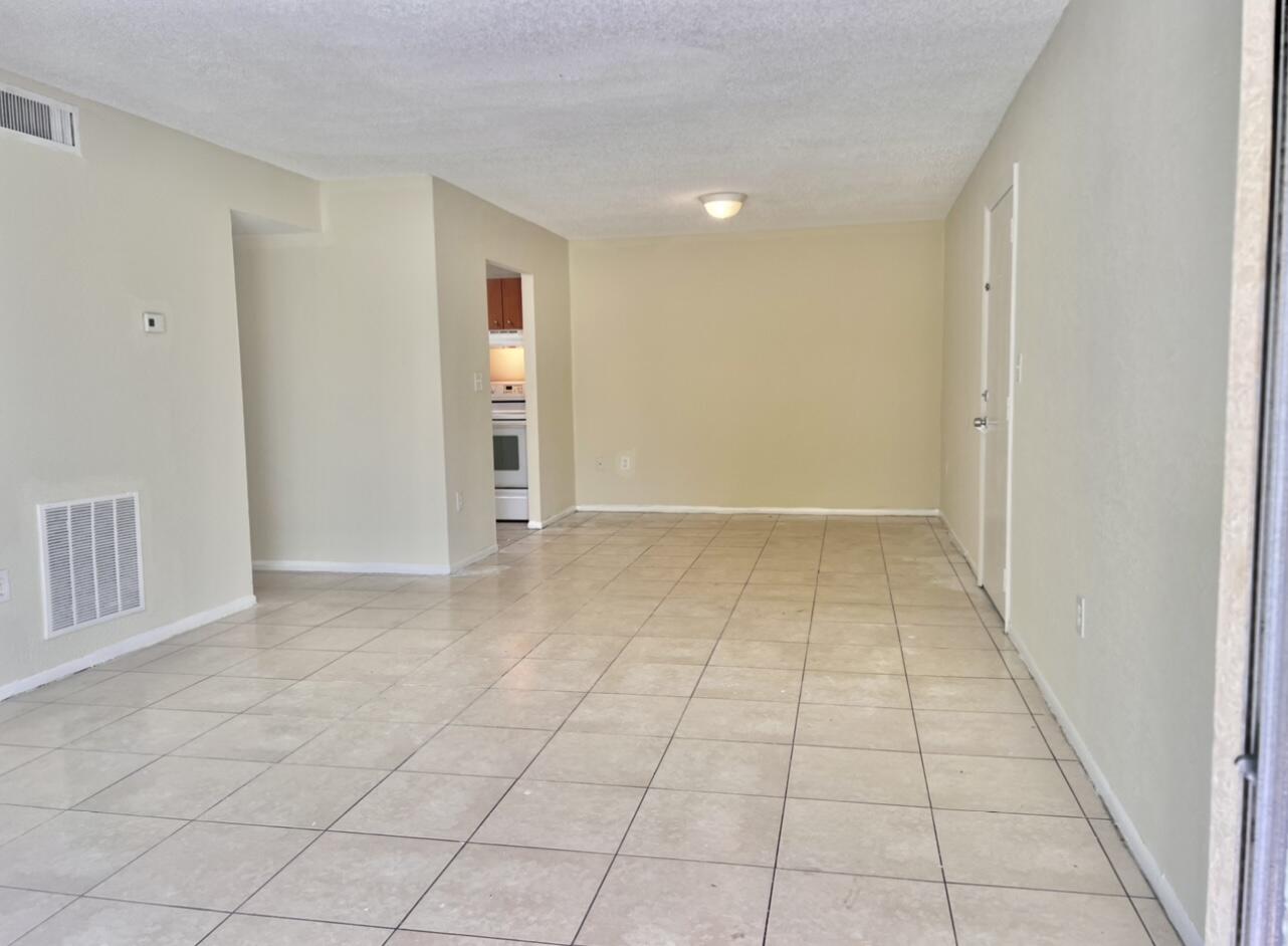 415 Executive Center Drive, Unit 213 West Palm Beach, FL 33401 - Photo 6 of 23 an empty room with white walls and tiles