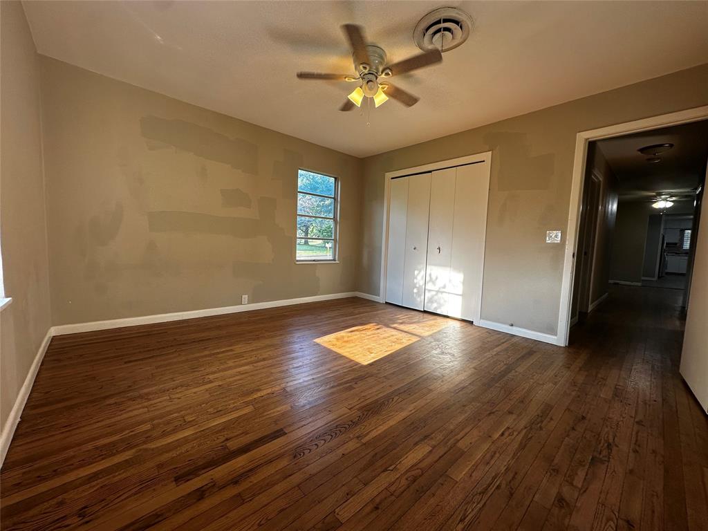 400 East Liberty Street Pilot Point, TX 76258 - Photo 6 of 16 Unfurnished bedroom with dark wood-style floors, a closet, and a ceiling fan
