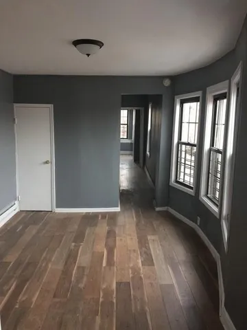a view of an empty room with glass door and windows