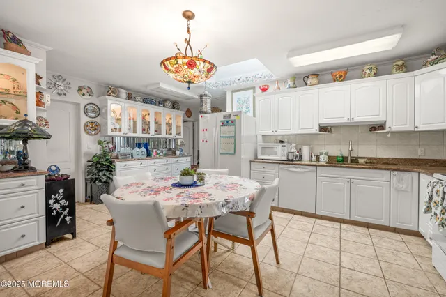 a kitchen with a dining table cabinets and stainless steel appliances