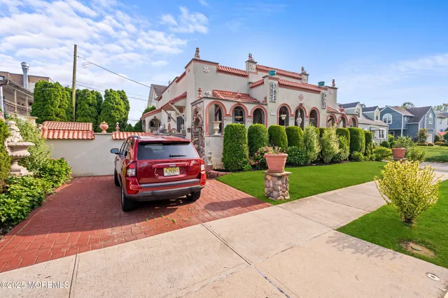 a car parked in front of a brick house with a yard