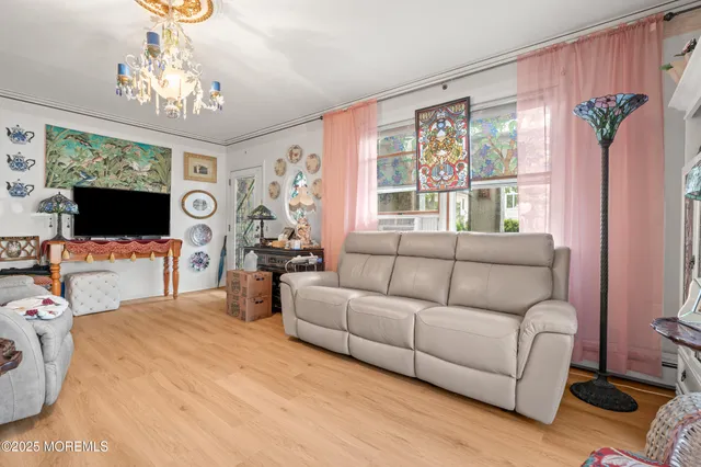 a living room with furniture a flat screen tv and a large window