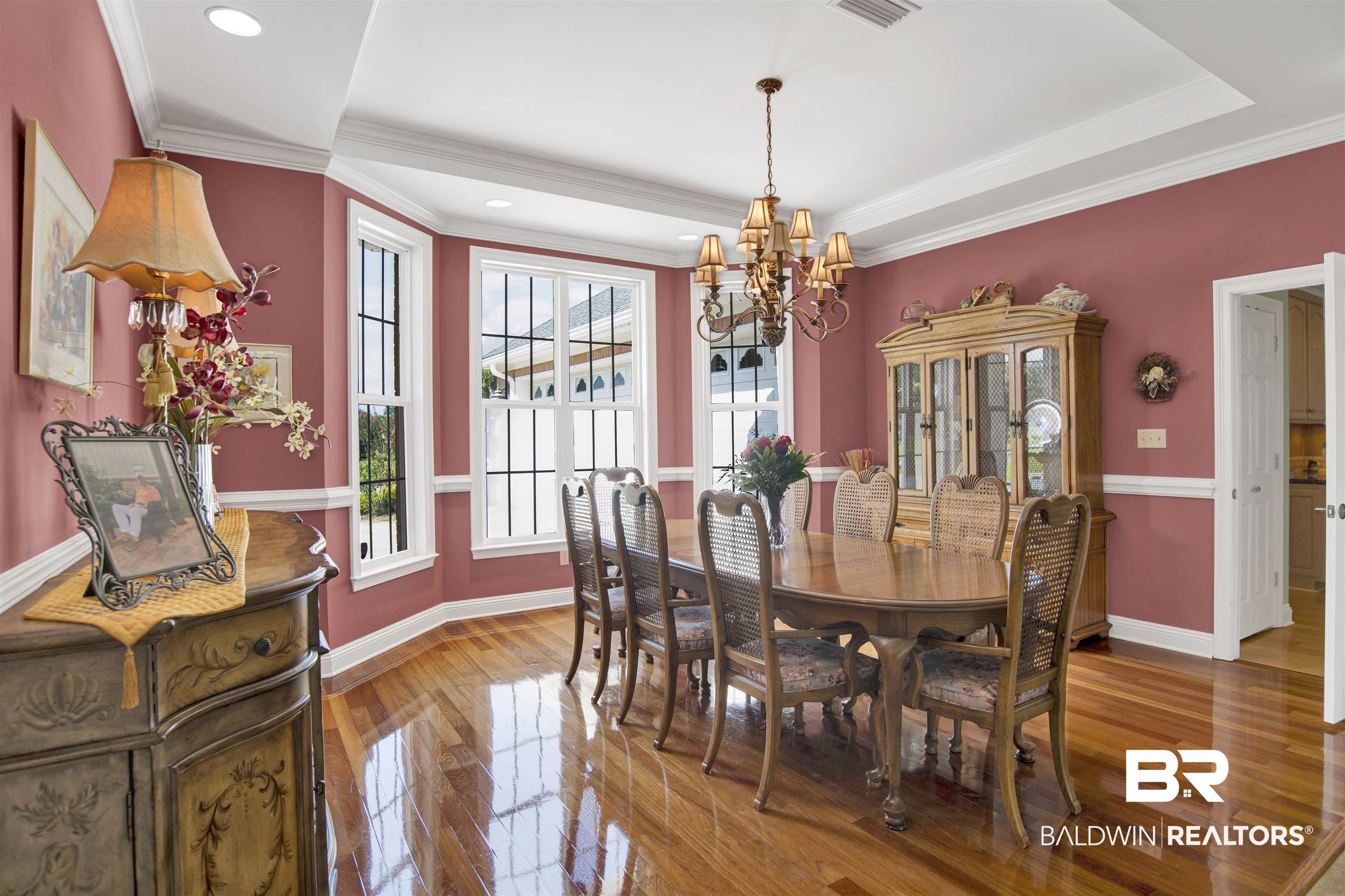 23014 Carnoustie Drive Foley, AL 36535 - Photo 17 of 49 Dining area with ornamental molding, wood finished floors, a chandelier, and a raised ceiling