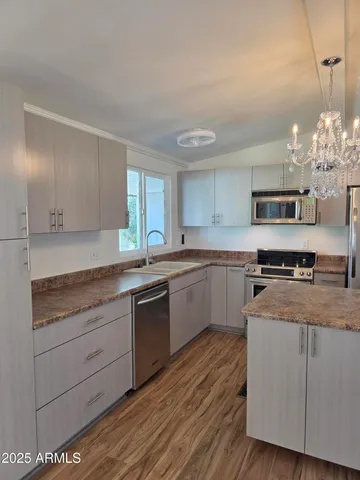 a view of a kitchen counter space a sink wooden floor and cabinets