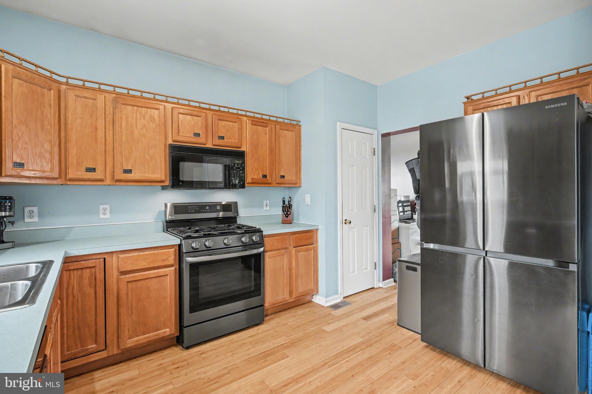 215 Birch Street Hamilton, NJ 08610 - Photo 20 of 38 a kitchen with a refrigerator stove and wooden cabinets